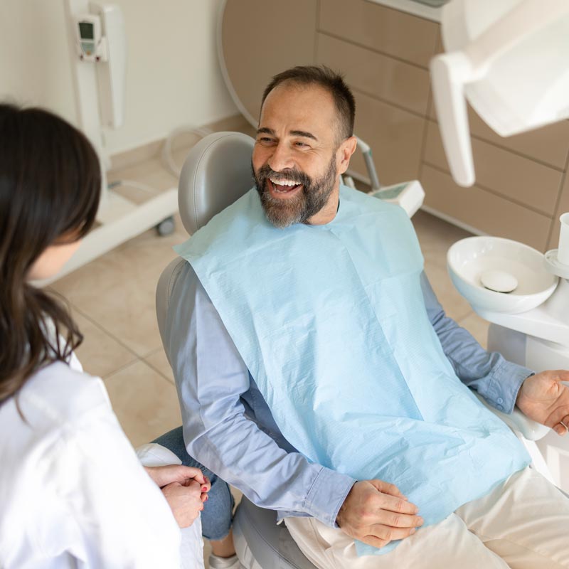Happy male patient talking to his dentist in medical clinic.