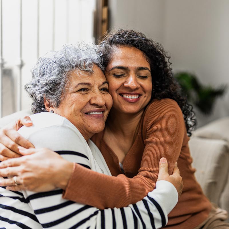 Mother and daughter embracing at home