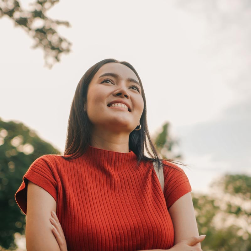 Smiling woman enjoying nature and freedom in sunny park setting